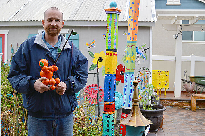 Tim Sullivan, creator of the orange men, poses at his parents’ house.